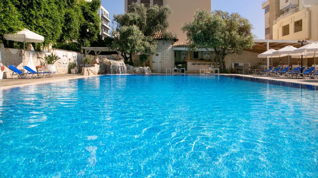 a large swimming pool with blue water in a building at Cleopatra Hotel in Nicosia