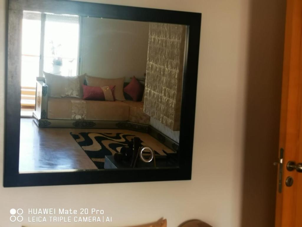 einen Spiegel an der Wand mit einem Sofa im Wohnzimmer in der Unterkunft Luxus Home in Oujda