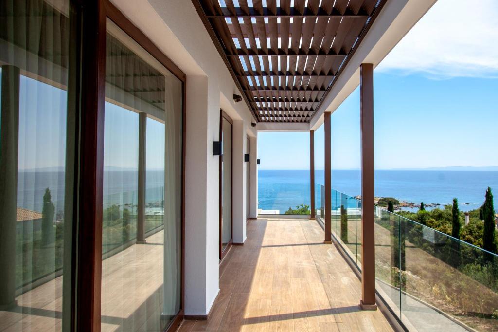 a view from the balcony of a house with glass windows at Zavia Penthouse in Sivota