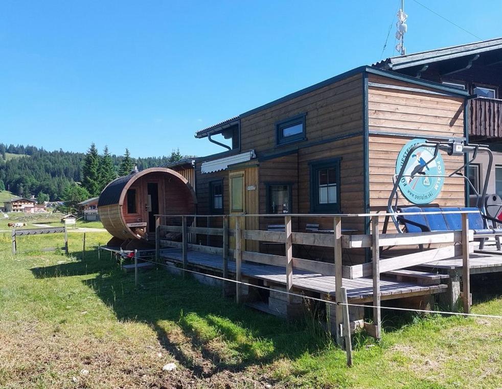 una cabaña de madera con una valla alrededor en Tinyhouse Postalm, en Abtenau