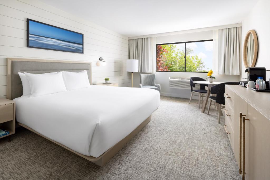 a hotel room with a large white bed and a desk at Pell Hotel JdV by Hyatt in Middletown