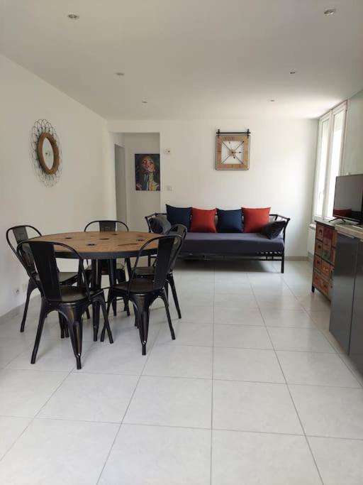 une salle à manger avec une table, des chaises et un canapé dans l'établissement F3 2sdb proche centre et route des plages, à Montpellier