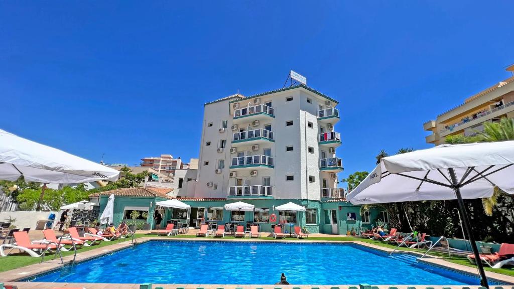 a hotel with a swimming pool in front of a building at Moon Dreams Fuengirola in Fuengirola