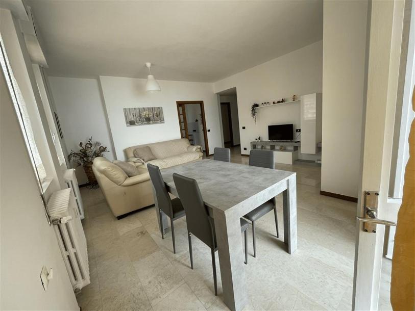 sala de estar con mesa, sillas y sofá en Fabula Home Rental - Casa Pluto en Lovere