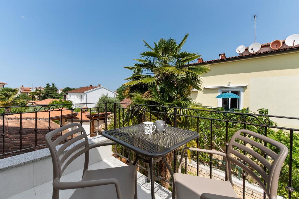 stół i krzesła na balkonie domu w obiekcie Villa Hope Apartments w Poreču