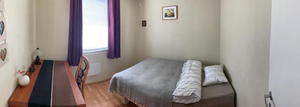 a bedroom with a bed and a window at Budget rooms on the way to Lofoten in Harstad
