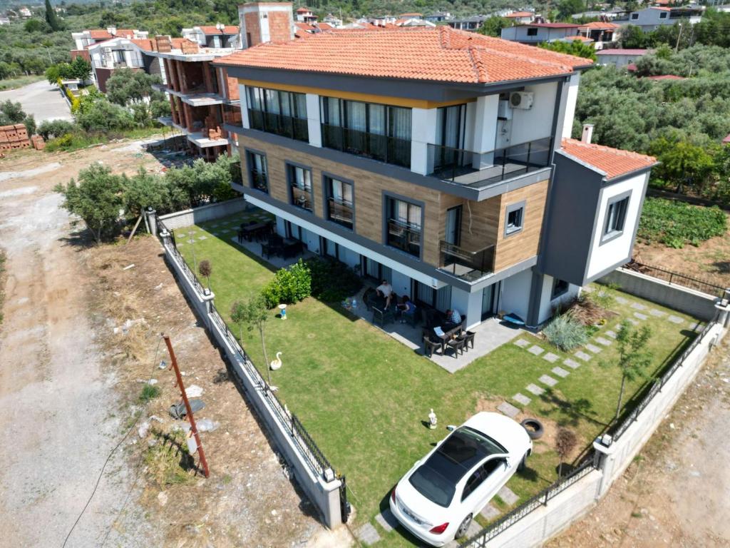 an aerial view of a house with a car on the yard at KUŞADASI DAVUTLARDA 4+1 ÖZEL BAHÇELİ KİRALIK LÜKS VİLLA in Kuşadası
