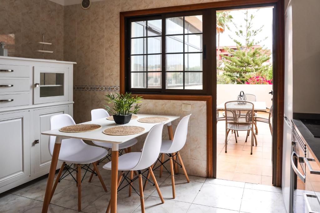 a kitchen with a white table and white chairs at Bright House, Pool & Workspace near Medano Beach in El Médano