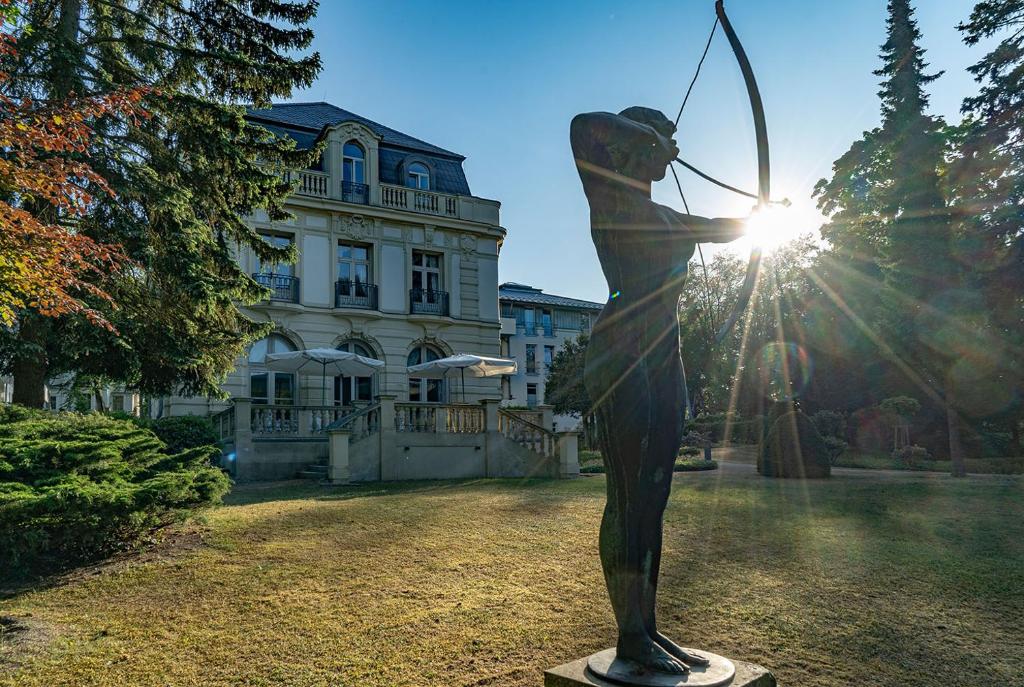 uma estátua de uma pessoa segurando um arco e flecha em Villa Bleichröder em Heringsdorf