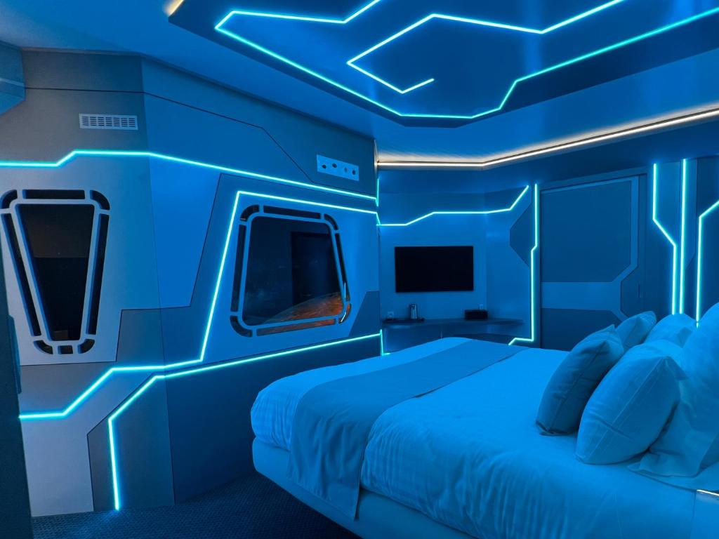 um quarto azul com uma cama e uma televisão em Inthemia em Tournai