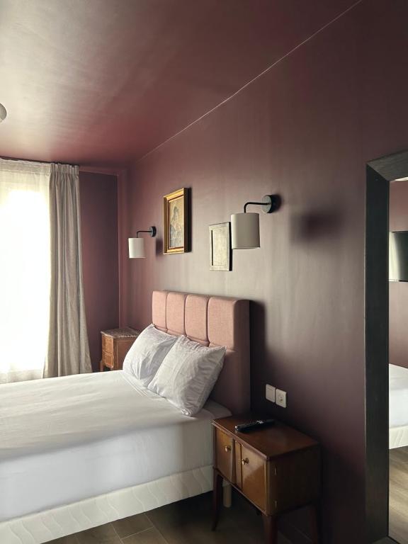 - une chambre avec un lit et deux lumières sur le mur dans l'établissement Hôtel Maât Etoile, à Paris