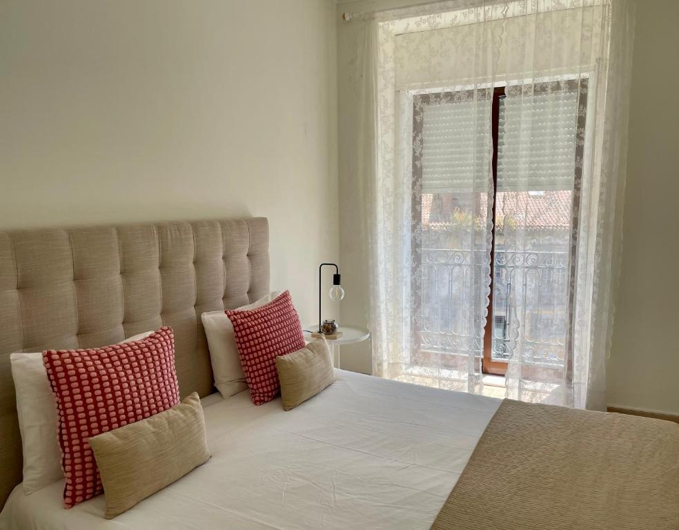 a bedroom with a large bed with pillows and a window at Old Town Cozy Apartment in Porto