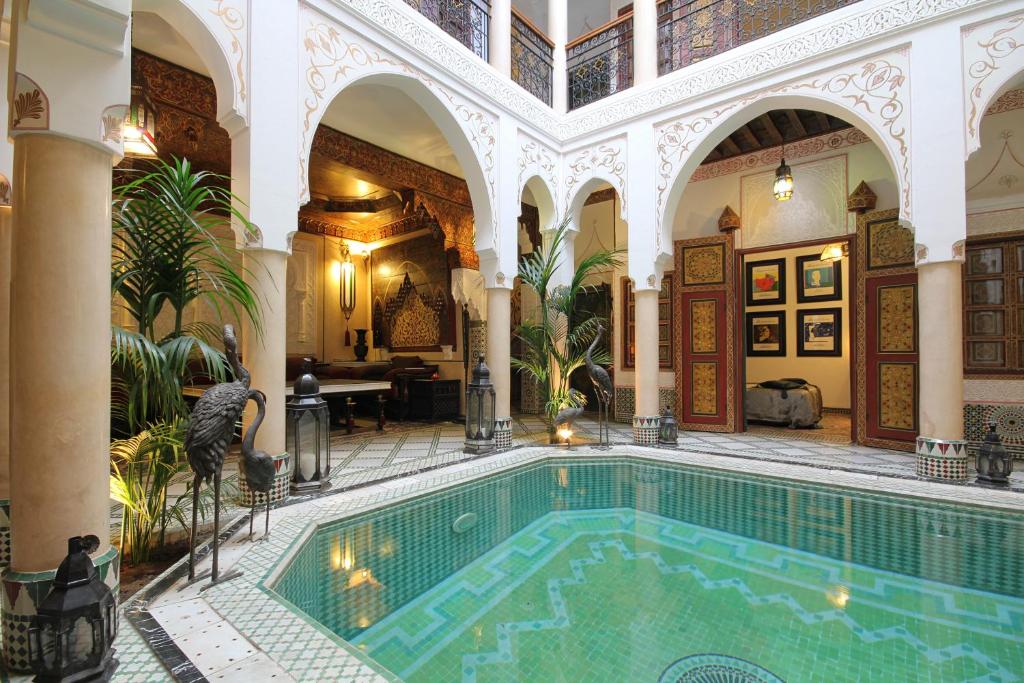 an indoor swimming pool in a building with a large building at Riad Esmeralda in Marrakesh