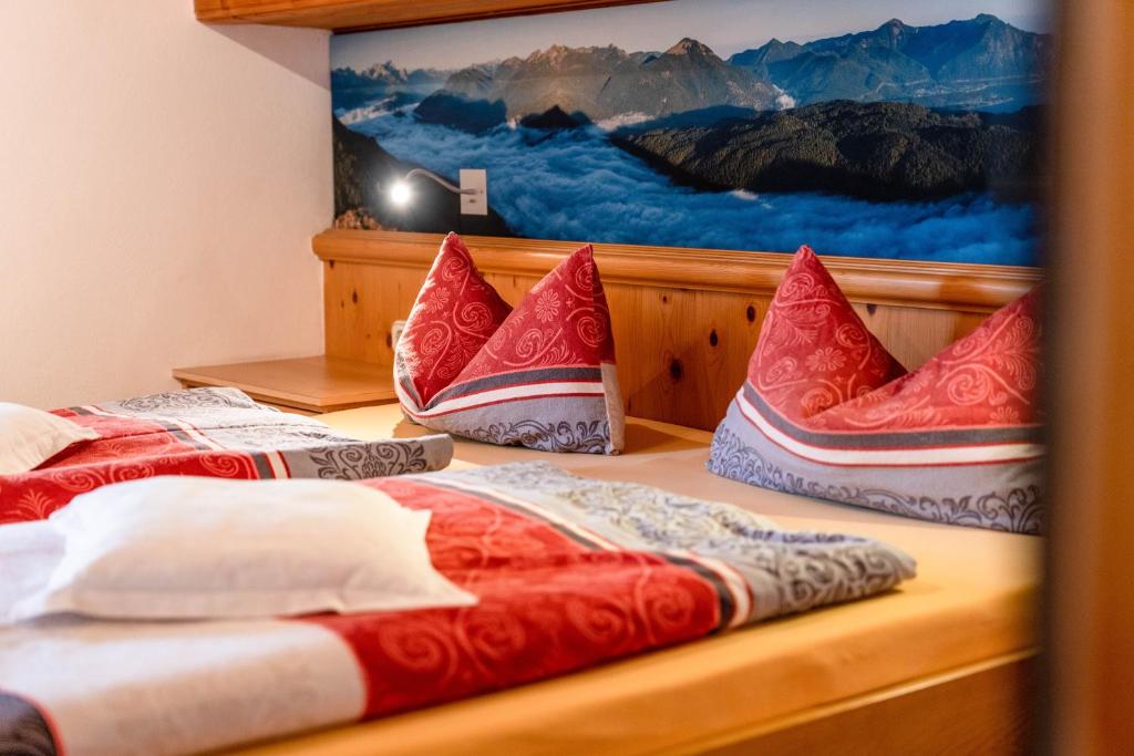 two beds in a room with red and white pillows at Walchensee - Alpenblick Tilly in Krün