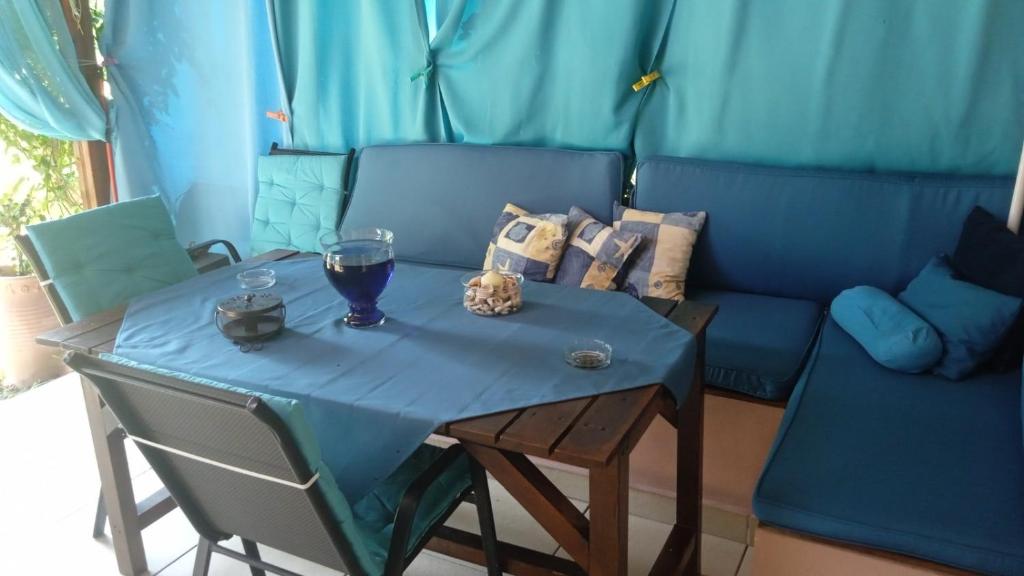 a table with a glass of wine and a couch at Nefeli Maisonette in Nikiti