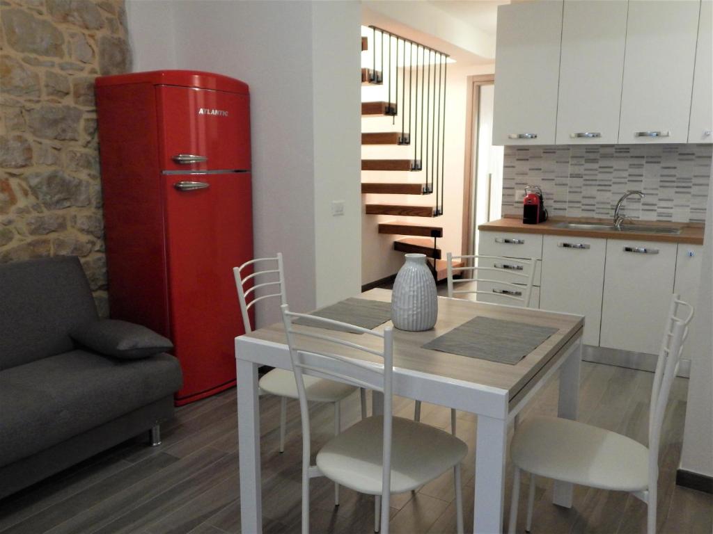 a kitchen with a table and a red refrigerator at Casa Foddis - Bed and View in Baunei