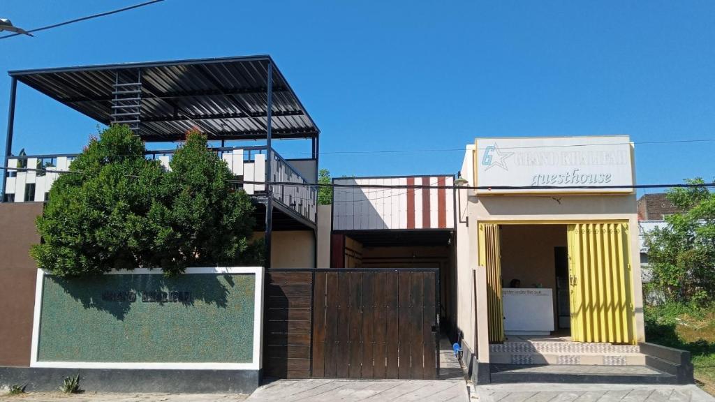 a house with a yellow door and a fence at GRAND KHALIFAH Guesthouse in Sumbawa Besar