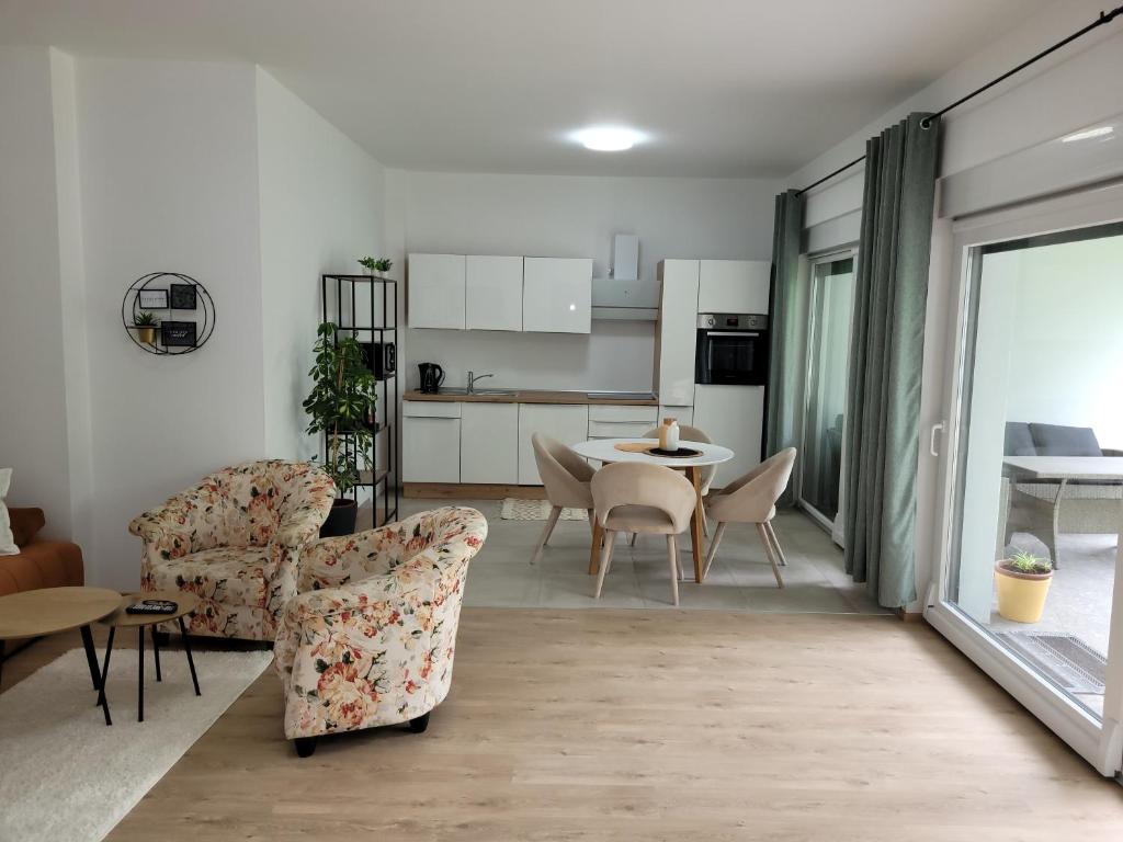 Villa LOE في فيلاخ: غرفة معيشة مع طاولة وكراسي ومطبخ