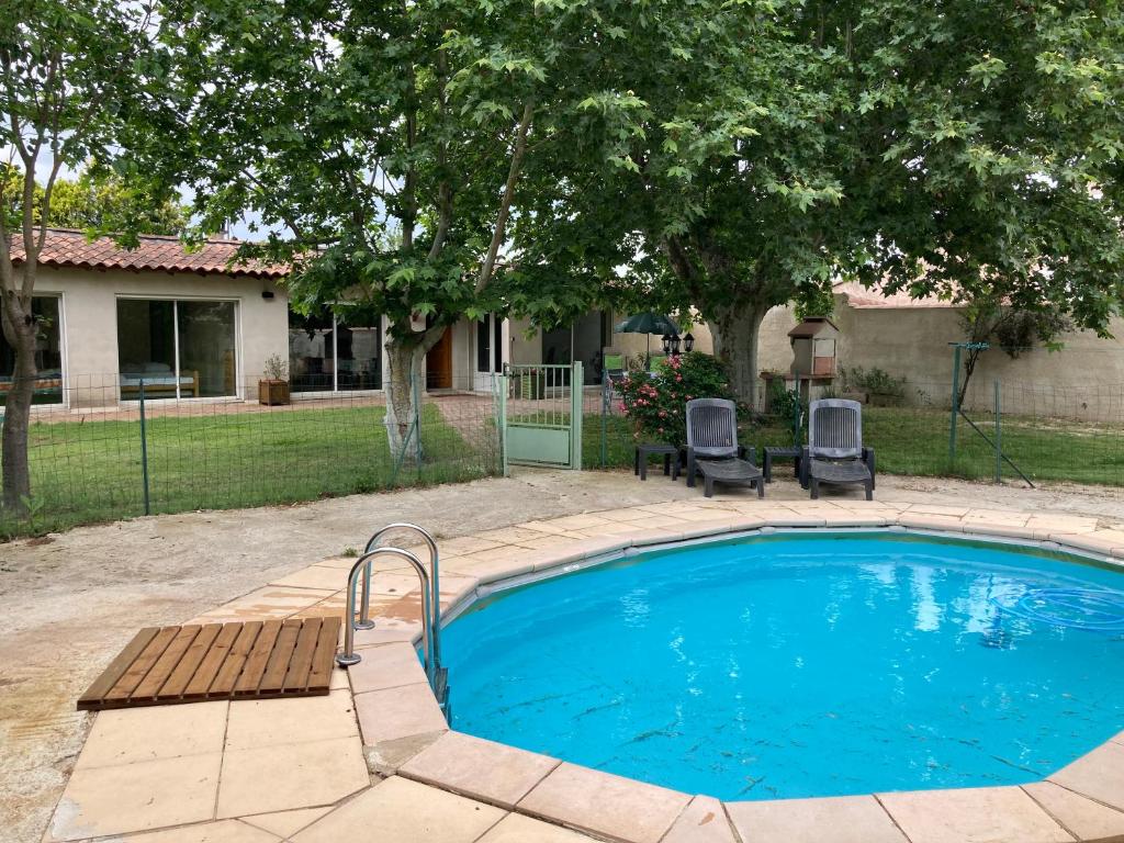 - une piscine avec 2 chaises à côté d'une maison dans l'établissement Villa les Platanes Aix en Provence, à Aix-en-Provence