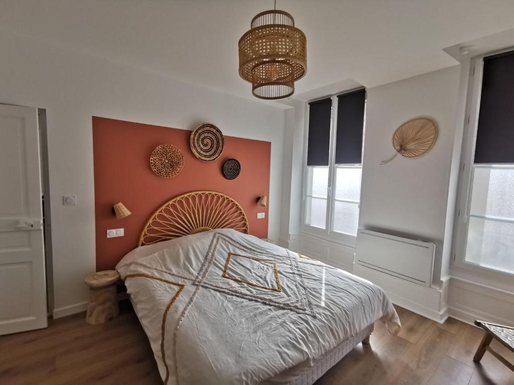 吉弗里的住宿－Clos Léonie - appartement 68m2 lumineux avec sauna，一间卧室配有一张带橙色墙壁的大床