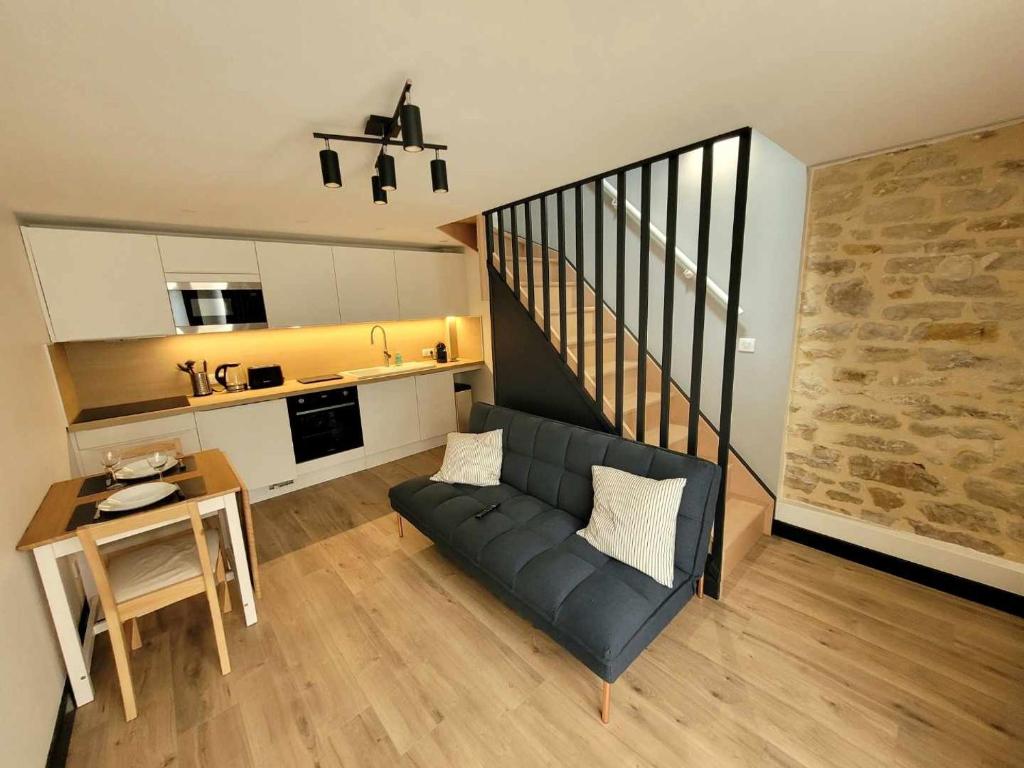 a living room with a couch and a table and a kitchen at Duplex Mon Désert - Parc Sainte Marie - Nancy Thermal in Nancy