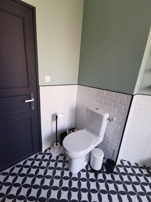 a bathroom with a toilet and a black door at Clos Léonie - appartement 68m2 lumineux avec sauna in Givry