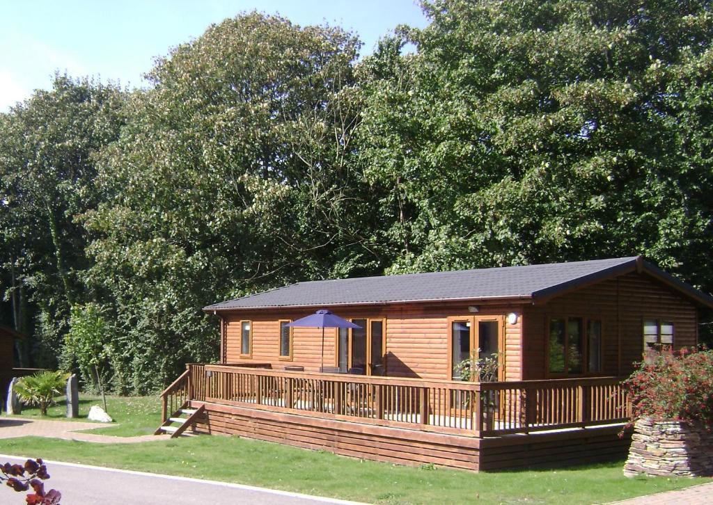 a log cabin with a porch and a deck at 10 Trehawks in Wadebridge