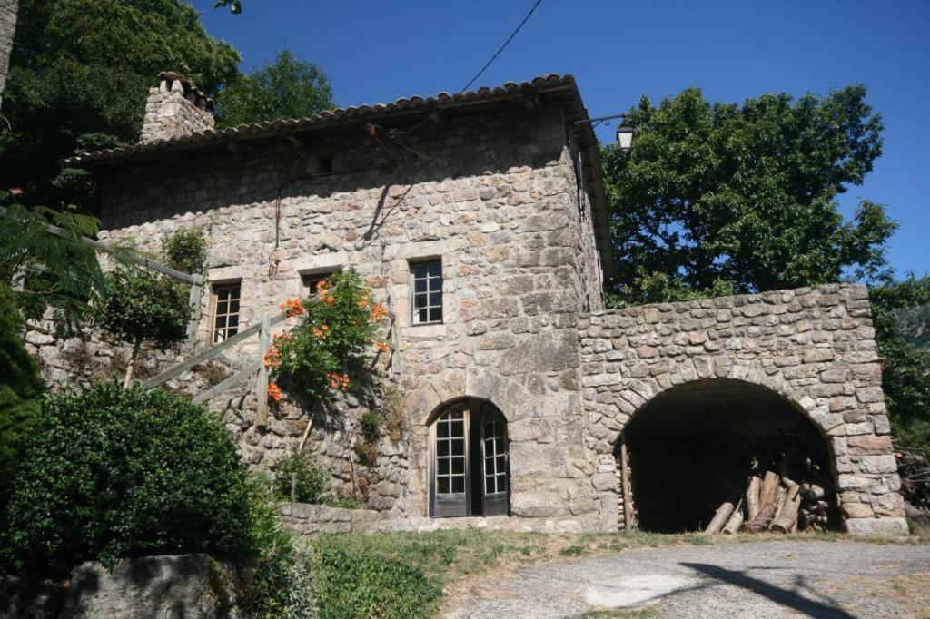 Montpezat-sous-Bauzon的住宿－Les Grisiéres，前面有隧道的古老石头建筑