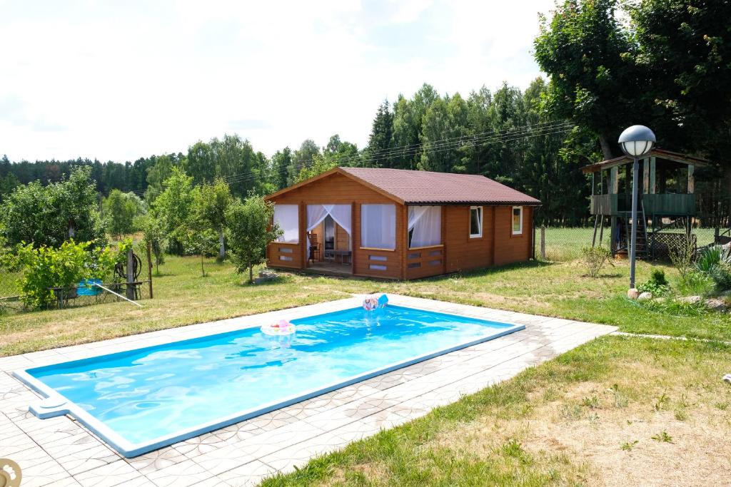 ein Haus mit einem Pool und einer Hütte in der Unterkunft Mark VI Mirotki 12 ImWald Bory Tucholskie in Skórcz