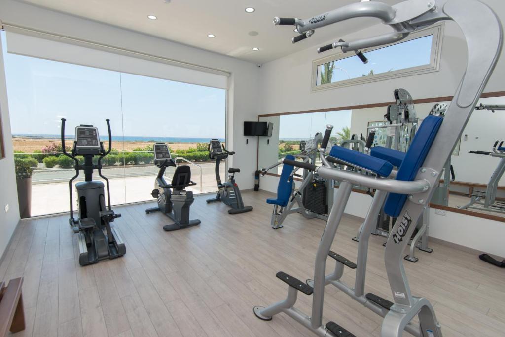 a gym with several tread machines and a large window at Loutsiana Deluxe Apts in Ayia Napa