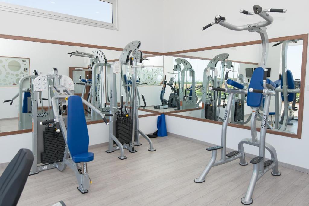 a gym with tread machines and a mirror at Loutsiana Deluxe Apts in Ayia Napa