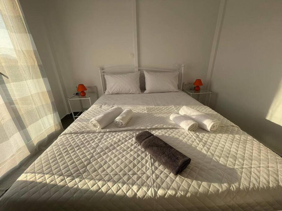 a white bed with two pillows and a towel on it at Villa Μyrtali in Meganisi