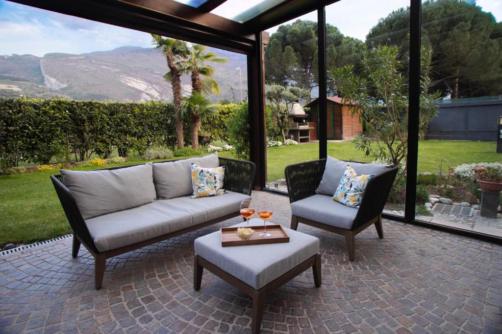 a patio with two chairs and a couch and a table at Villetta al lago in Nago-Torbole