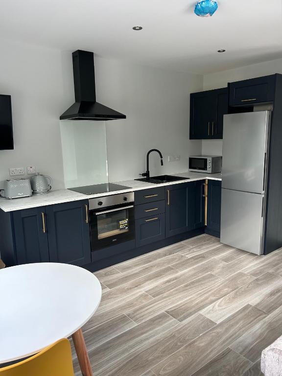 a kitchen with blue cabinets and a white refrigerator at Stylish Killorglin Apartment in Killorglin