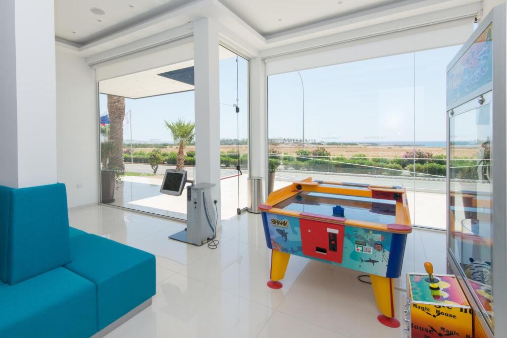 a living room with a pool table and a blue couch at Loutsiana Deluxe Apts in Ayia Napa