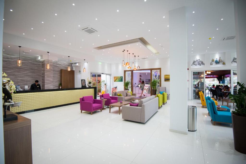 a lobby with colorful chairs and a counter at Loutsiana Deluxe Apts in Ayia Napa