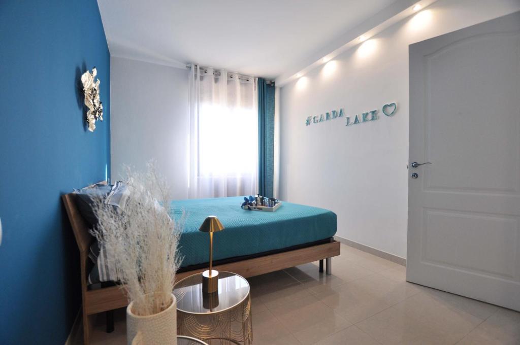 a room with a blue bed and a window at Dalila's Apartment in Sirmione