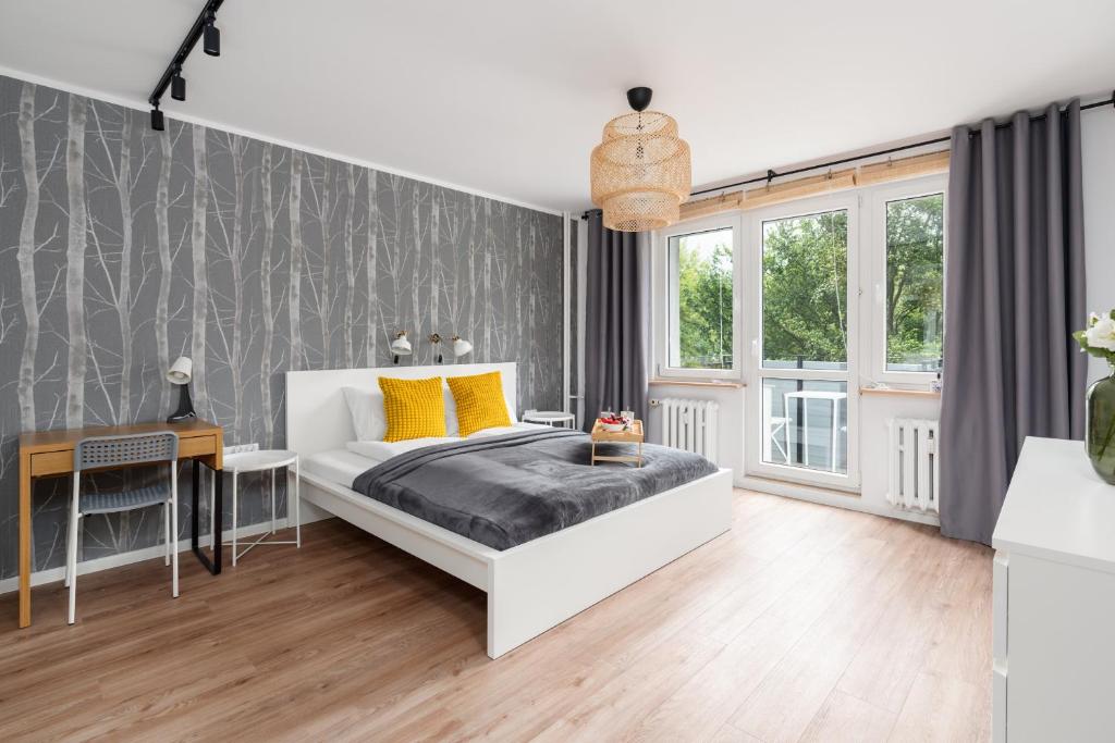 a bedroom with a large bed and a desk at Green View Apartment with Balcony Winogrady by Noclegi Renters in Poznań