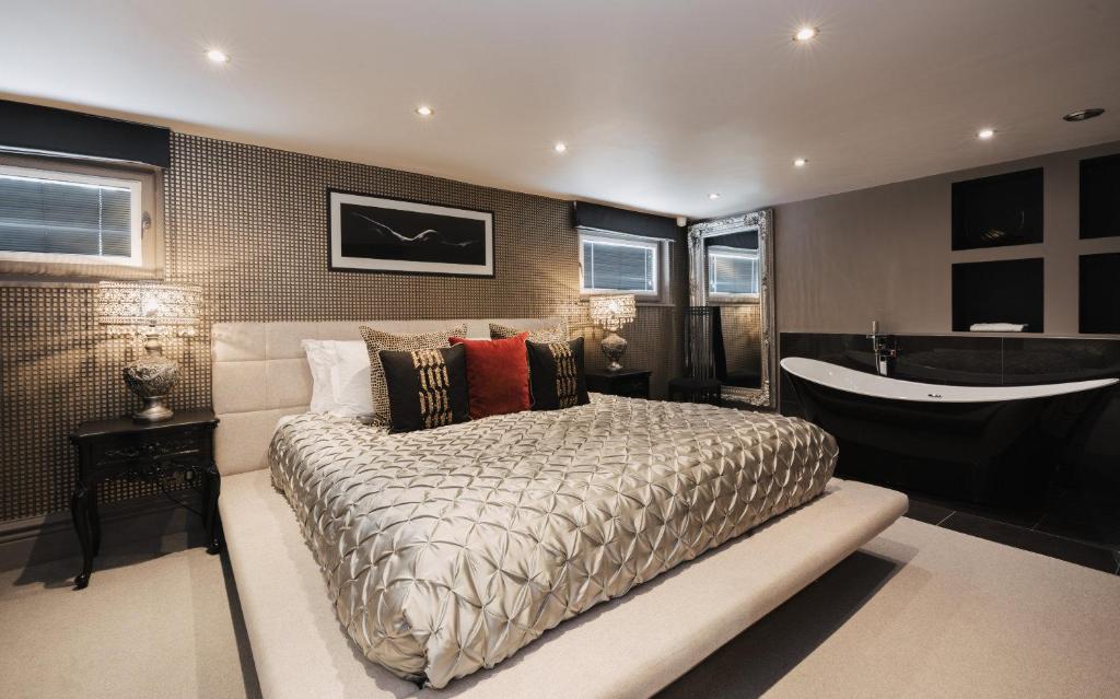 a bedroom with a large bed and a bath tub at Square Townhouse in Brighton & Hove
