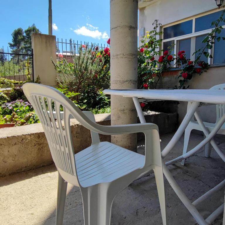 a white table and a white chair on a patio at Zia Peppina in Tertenìa