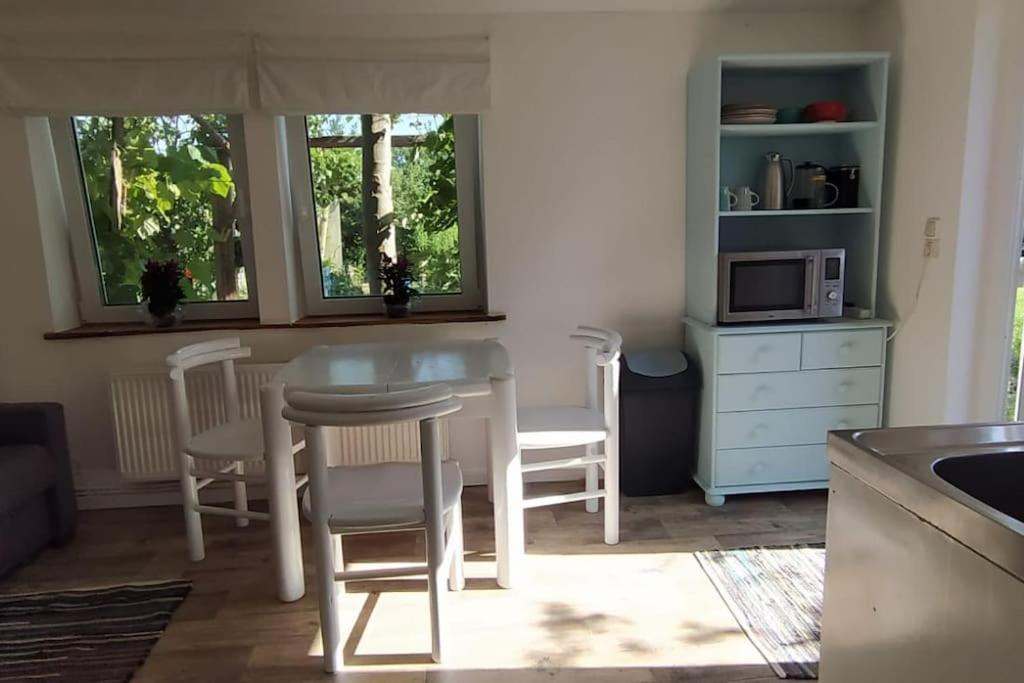 una cucina con tavolo, sedie e forno a microonde di FairSchlafen a Bücken