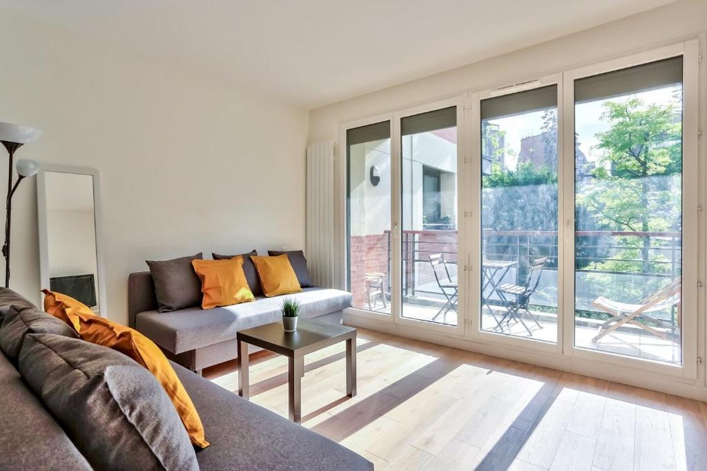 uma sala de estar com um sofá e uma mesa em Studio - Appartement Quartier Montparnasse 2 em Paris