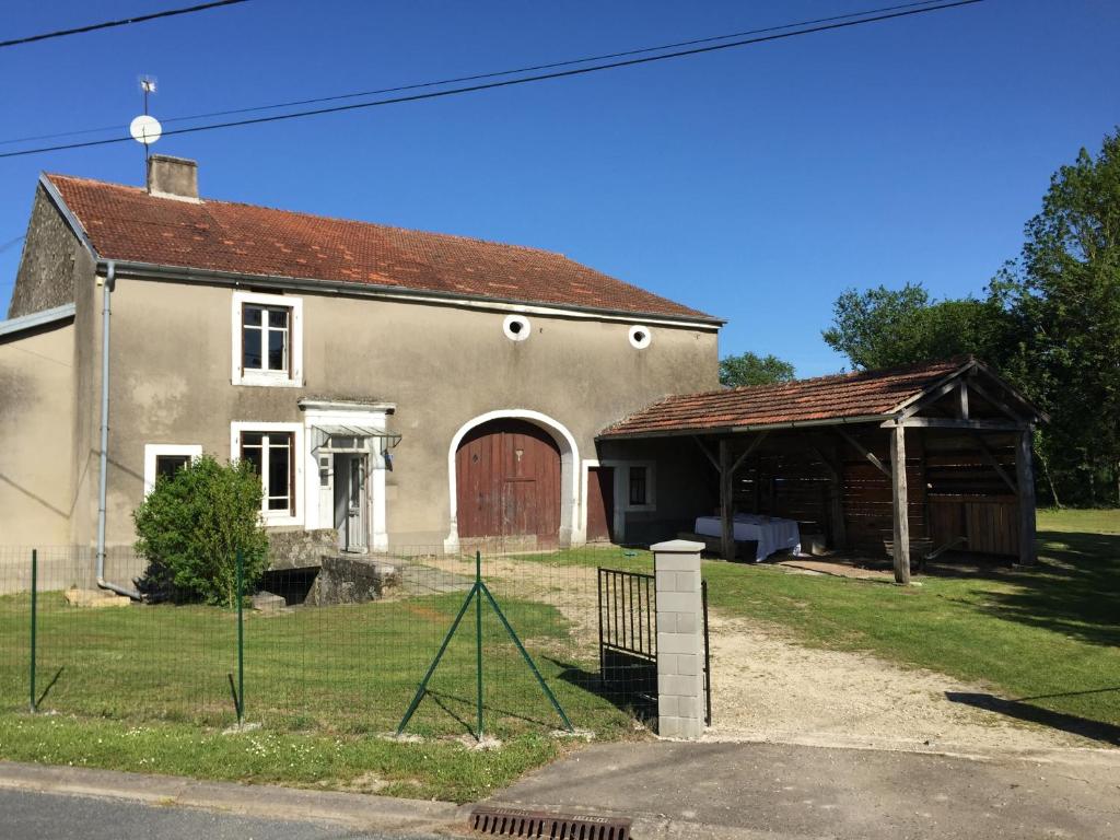 ein Haus mit einer roten Tür und einer Scheune in der Unterkunft Maison du Bûcheron in Melay