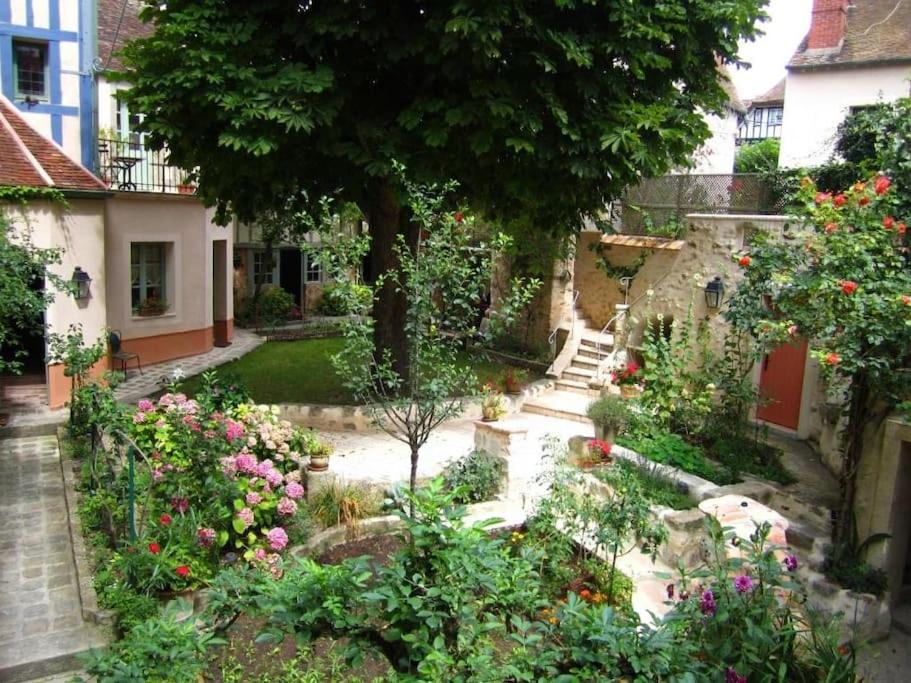 a garden with flowers and plants in front of a house at LIVING'Melun, la campagne à Melun ! in Melun