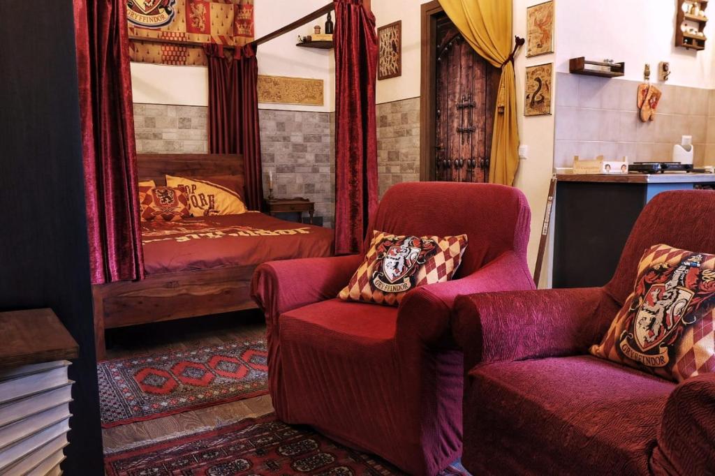 un soggiorno con 2 sedie e un letto di La Tana Rifugio per Maghi e Streghe a Cantalupo in Sabina