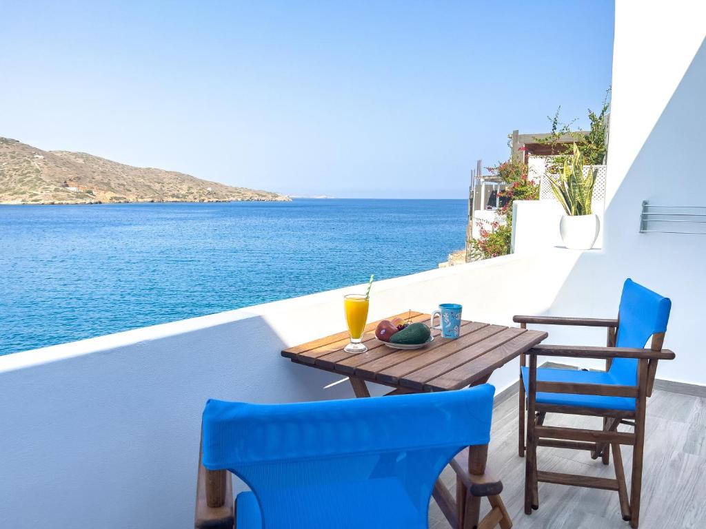 a table and chairs on a balcony overlooking the water at Gialos Studios in Katapola