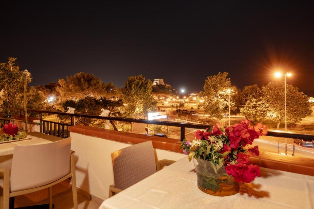 un jarrón de flores sobre una mesa en un balcón en B&B Torre Talao, en Scalea