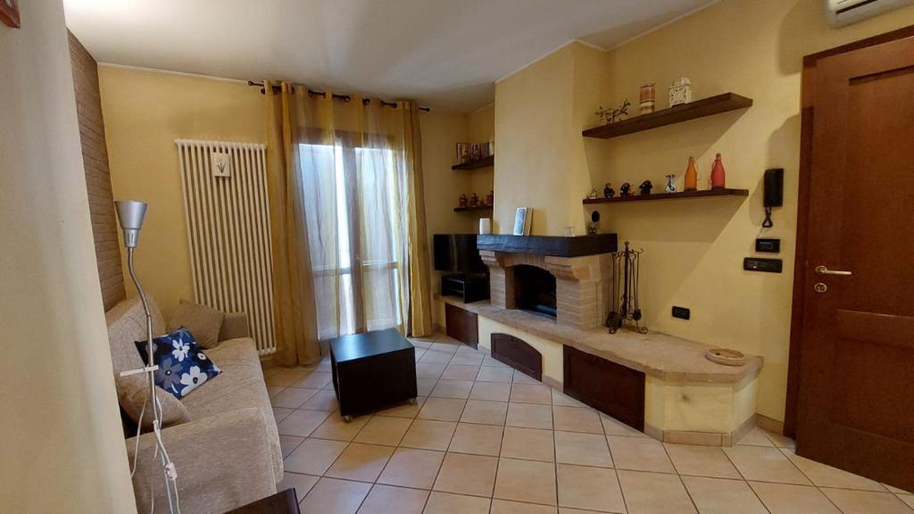 een woonkamer met een bank en een open haard bij Casa vacanze Andrea in Cattolica