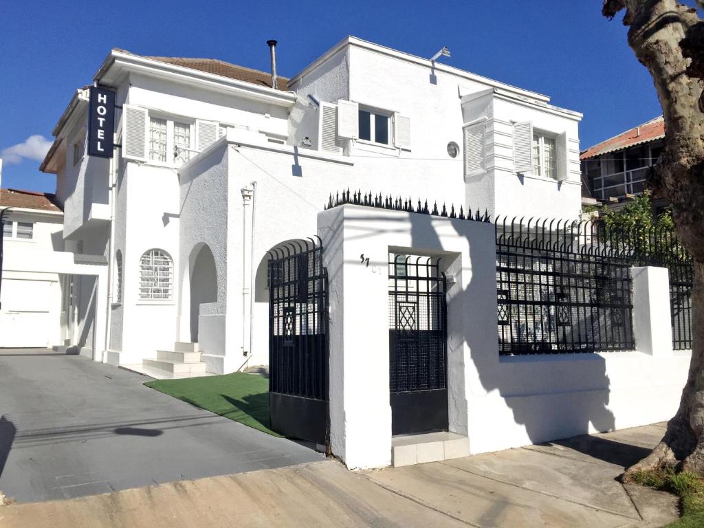 a white house with a black gate at New York Suites in Viña del Mar