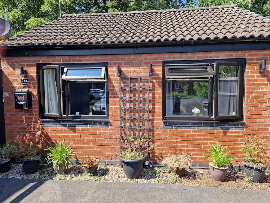 a red brick house with plants in front of it at Squirrel's Retreat in Thornton